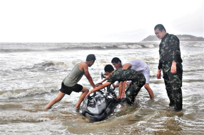 7月19日，受臺(tái)風(fēng)“威馬遜”影響，一條虎頭鯨受傷擱淺在廣東陽(yáng)江市海陵島附近海域，武警邊防官兵嘗試著將鯨魚送到深水區(qū)。