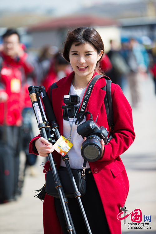 2016年兩會，人民大會大堂前，一位笑容燦爛的紅衣女記者正步入大會堂。中國網(wǎng) 鄭亮 攝