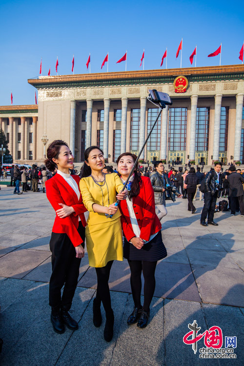 2015年3月5日，第十二屆全國人大第三次會議開幕會，三位女記者在人民大會堂前合影留念。中國網 鄭亮 攝