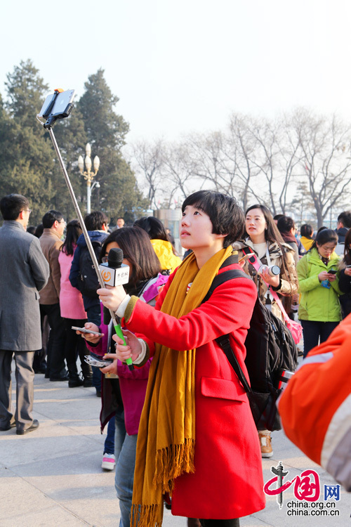 2015年兩會，來自山東的一位紅衣美女記者在人民大會堂前自拍留念。中國網(wǎng) 董寧 攝